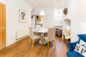 a dining room and living room with a table and chairs at Stamford Park Road by YourStays! in Altrincham