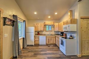 a kitchen with white appliances and wooden cabinets at Grinnell Cabin BBQ, Kitchen, 7 Mi to Glacier NP in Coram