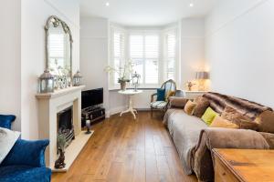 a living room with a couch and a fireplace at Stamford Park Road by YourStays! in Altrincham