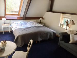 ein Schlafzimmer mit einem Bett, einem Tisch und einem Stuhl in der Unterkunft B&B De Mersken in Ureterp