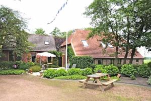 a wooden picnic table in front of a house at B&B De Mersken in Ureterp