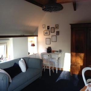 a living room with a blue couch and a table at B&B De Mersken in Ureterp