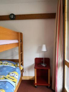 ein Schlafzimmer mit einem Etagenbett und einem Tisch mit einer Lampe in der Unterkunft Résidence DIGITALE, Le Lauze Plagne 1800 in Plagne 1800