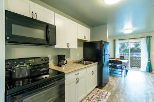 a kitchen with a black refrigerator and a sink at Ocean Breeze Inn in Keaau