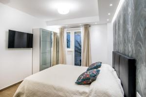 - une chambre avec un lit et une télévision murale dans l'établissement Dubrovnik Spectrum Rooms, à Dubrovnik