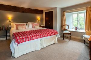 a bedroom with a large bed and a chair at Bridge Farmhouse B&B in Hereford