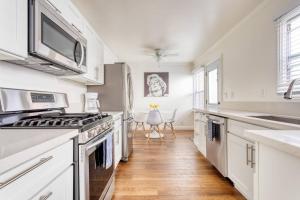 a kitchen with white appliances and wooden floors at New Beach Jewel Bungalow in Long Beach