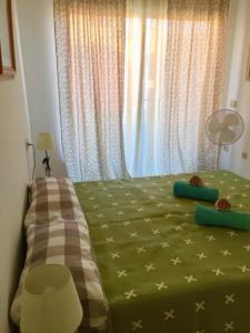 プエルト・デ・サンティアゴにあるjardines del marのベッドルーム1室(緑色のベッド1台、窓付)