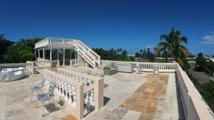 een grote patio met een witte leuning en een trap bij Villa Marsana in Aguada
