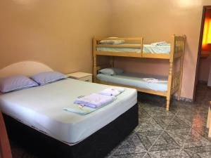 a bedroom with two beds and a bunk bed at Pousada Beira Mar in Rio das Ostras