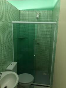 La salle de bains est pourvue d'une douche, de toilettes et d'un lavabo. dans l'établissement Pousada Beira Mar, à Rio das Ostras