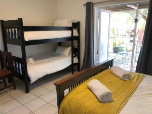 sypialnia z 2 łóżkami piętrowymi i żółtym łóżkiem w obiekcie The Solomon Guest House w mieście Kimberley