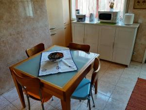eine Küche mit Tisch und Stühlen und einem Tisch und einer Mikrowelle in der Unterkunft Casa Júnior in Arouca