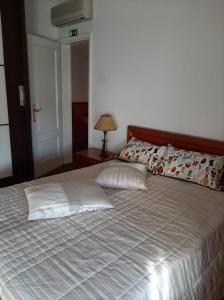 a bedroom with a large bed and a lamp on a table at Casa Júnior in Arouca