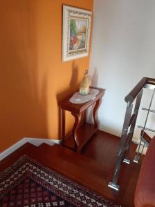 a small table with a vase on it next to a staircase at Casa Júnior in Arouca
