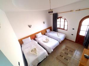 duas camas num quarto com lençóis brancos em Jimmy Hotel em Dahab