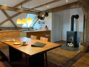 a kitchen with a wooden table and a wood stove at Benefizium Denklingen - Anno 1713 in Denklingen