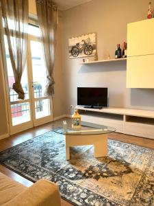 a living room with a coffee table and a tv at Franciacorta flat & bollicine in Passirano +13 photos