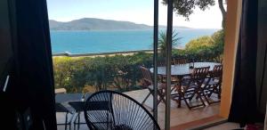 Un balcón con mesa y sillas y el mar. en Mini villa n2, en Olmeto 5 fotos más