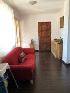 ein rotes Sofa im Wohnzimmer mit Tür in der Unterkunft Bestapartman in Balatonboglár