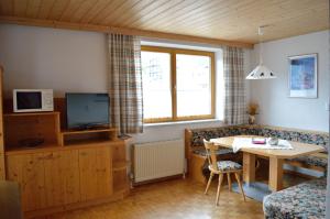 ヴィルゲンにあるFerienwohnung Kogelblickの小さなリビングルーム(テーブル、テレビ付)