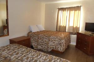 Un pat sau paturi într-o cameră la Daytona Shores Inn and Suites