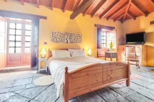 a bedroom with a bed and a flat screen tv at Finca el Rincón in Arona