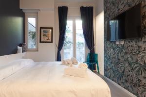 um quarto com uma grande cama branca com toalhas em CasaVostra al Parco em Catânia