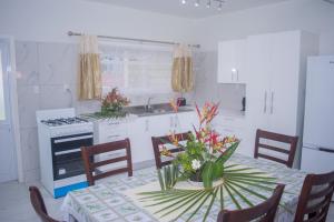 a kitchen with a table with a vase of flowers on it at MOEROA VILLAS in Avatiu