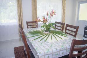 a dining room table with a vase of flowers on it at MOEROA VILLAS in Avatiu