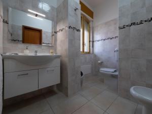 uma casa de banho com um lavatório e um WC em L'Onda em Marina di Ragusa