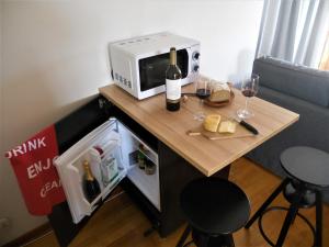 a small table with a microwave and wine glasses on it at Galo Preto - Amazing breakfast Sintra - View and Silence in Sintra