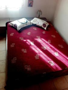 a bed with a red blanket on top of it at Cosy house in Galaxidi in Galaxidhion