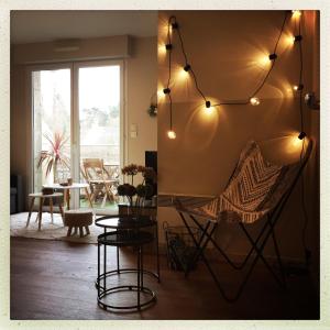 a living room with a chair and a table at Bel appartement la Forêt-Fouesnant vue sur la baie in La Forêt-Fouesnant