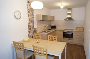 a kitchen with a wooden table and chairs and a kitchen with a sink at Apartmány IVKA a MAŤKO DONOVALY 198 in Donovaly
