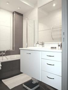 Baño blanco con lavabo y bañera en Appartement en Niza