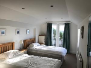 a bedroom with two beds and a window at Seacroft in Woolacombe