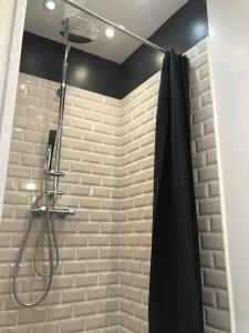 La salle de bains est pourvue d'une douche avec rideau de douche noir. dans l'établissement Résidence du Port, au Tréport