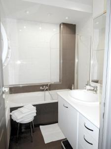 a bathroom with a sink and a tub and a mirror at Appartement in Nice