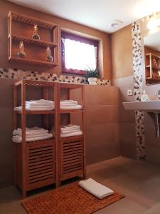 ein Badezimmer mit Waschbecken und einem Regal mit Handtüchern in der Unterkunft super gemütlich - DasPaterhaus in Monschau
