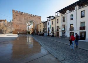 dos personas caminando por una calle en una ciudad en Casa Flor del Naranjo en Granada