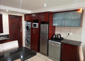 a kitchen with stainless steel appliances and wooden cabinets at Nautica Flat 301 in Mossel Bay