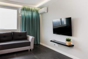a living room with a couch and a flat screen tv at WarsawSkyLine Apartments - PGE Narodowy, Torwar, Bulwary Wiślane in Warsaw