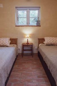 a room with two beds and a table with a lamp at Brösarp Källagården Lilla Gårdslägenheten in Brösarp
