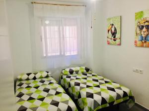 a bedroom with two beds and a window at Apartamento Santa Pola"The Guitar" 300 m de la playa in Santa Pola