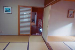 a living room with a door and a staircase at 山荘民宿 in Hashiba