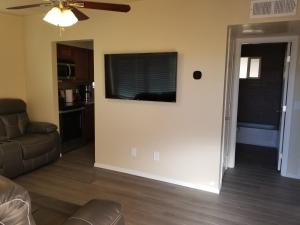 een woonkamer met een bank en een televisie aan de muur bij Southwest Tucson Gateway in Tucson
