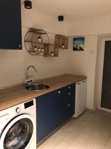 a kitchen with a washing machine and a sink at City Centre One in Skopje