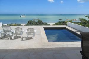 een zwembad met stoelen en uitzicht op de oceaan bij Designer´s House Beach Front Superb Ocean View Hi Speed WiFi in Telchac