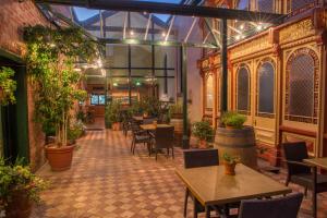 a restaurant with tables and chairs and potted plants at Vue Grand Hotel in Queenscliff
